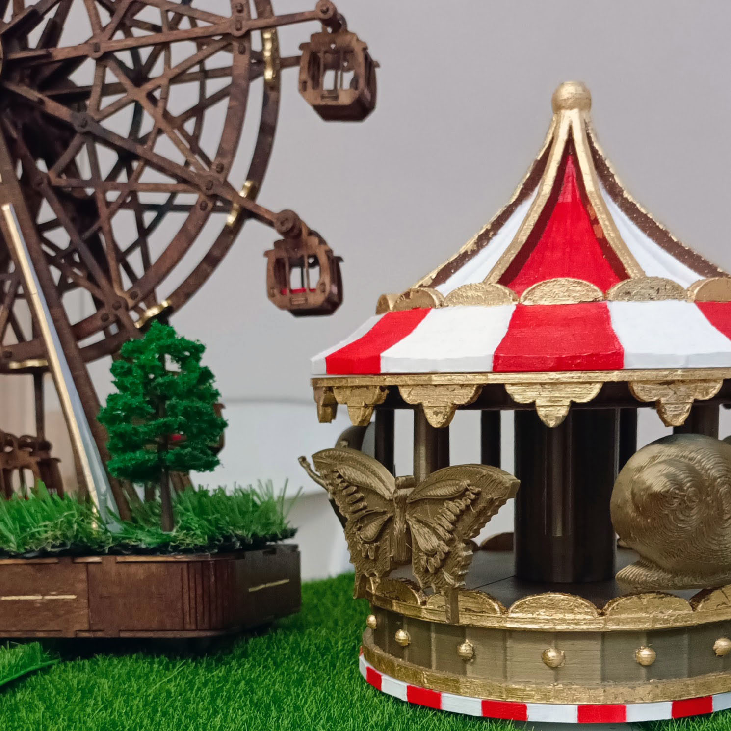 Detail of the red-and-white striped carousel with the Ferris wheel rising behind it